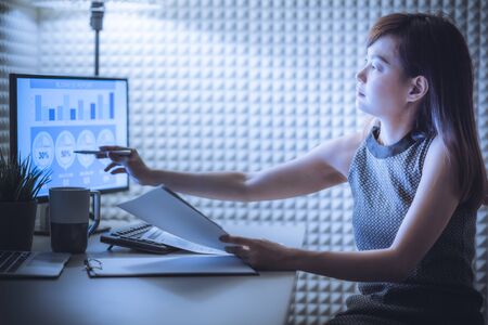 Asian business woman reviewing data in financial charts and graphs. Accountingの写真素材