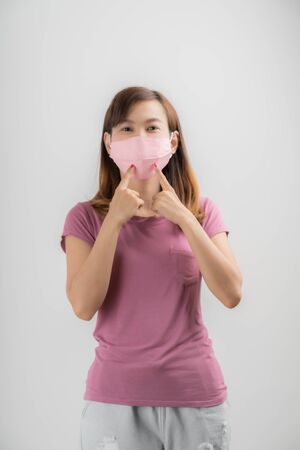 Close up portrait of young woman with medicine health care mask against white white background. CoronaVirus, Covid-19. Asian peopleの写真素材