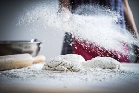 Making dough by female hands at bakeryの写真素材