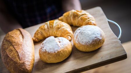 Woman Hands Hold Wooden Tray Present Fresh Baked Bakeryの写真素材