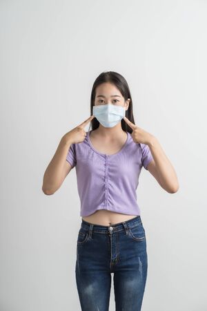 Close up portrait of young woman with medicine health care mask against white white background. CoronaVirus, Covid-19. Asian peopleの写真素材