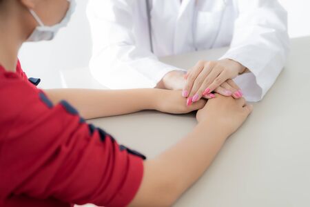 Hand of doctor reassuring her female patient. Asian peopleの写真素材