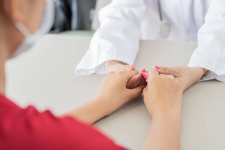 Hand of doctor reassuring her female patient. Asian peopleの写真素材