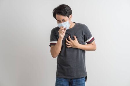 Portrait of young man with medicine health care mask against white gray background. Asian peopleの写真素材