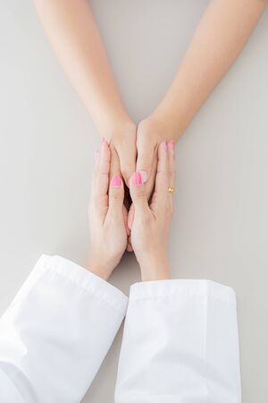 Hand of doctor reassuring her female patient. Asian peopleの写真素材