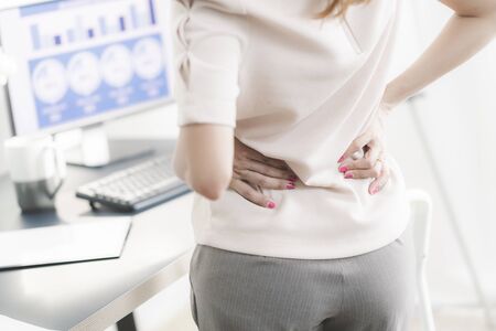 Business woman with back pain in office. Asian people. Work at home conceptの写真素材