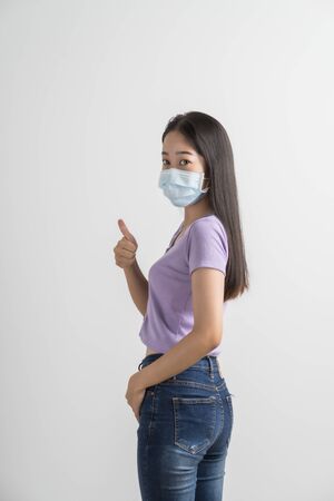 Close up portrait of young woman with medicine health care mask against white white background. CoronaVirus, Covid-19. Asian peopleの写真素材