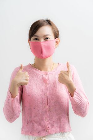 Close up portrait of young woman with medicine health care mask against white white background. CoronaVirus, Covid-19. Asian peopleの写真素材