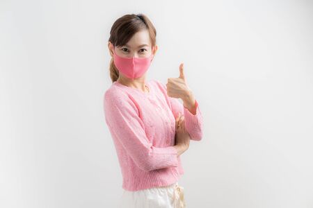 Close up portrait of young woman with medicine health care mask against white white background. CoronaVirus, Covid-19. Asian peopleの写真素材