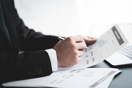 Businessman analyzing investment charts with laptop. Accounting conceptの写真素材