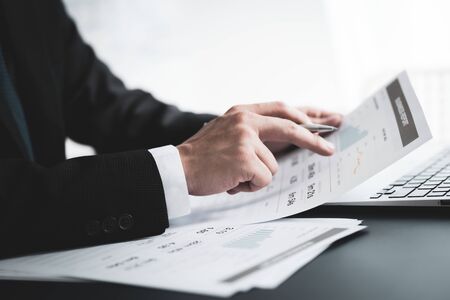 Businessman analyzing investment charts with laptop. Accounting conceptの写真素材