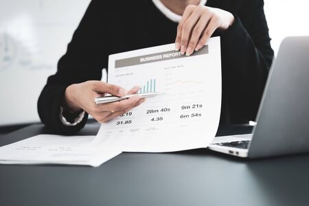 Asian business woman reviewing data in financial charts and graphs. Accounting conceptの写真素材