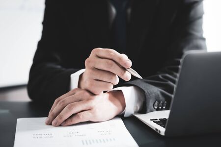 Businessman analyzing investment charts with laptop. Accounting conceptの写真素材