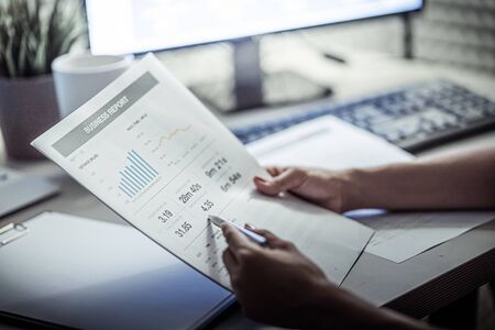 Asian business woman reviewing data in financial charts and graphs. Accountingの写真素材