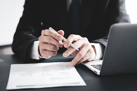 Businessman analyzing investment charts with laptop. Accounting conceptの写真素材