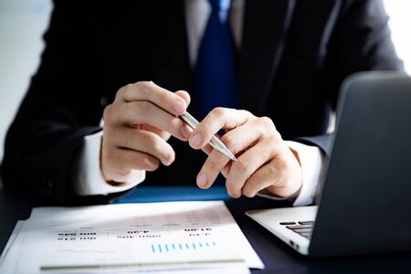 Businessman analyzing investment charts with laptop. Accounting conceptの写真素材