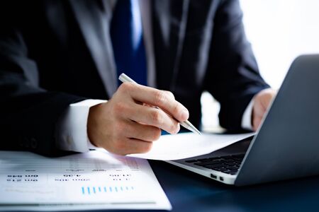 Businessman analyzing investment charts with laptop. Accounting conceptの写真素材