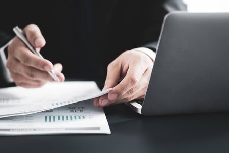 Businessman analyzing investment charts with laptop. Accounting conceptの写真素材