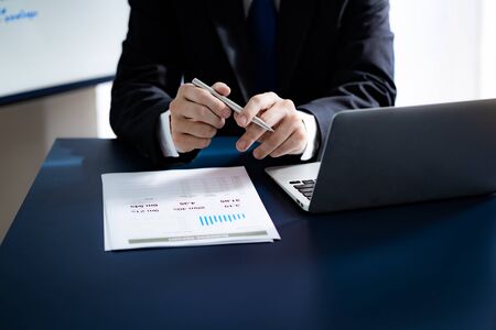 Businessman analyzing investment charts with laptop. Accounting conceptの写真素材