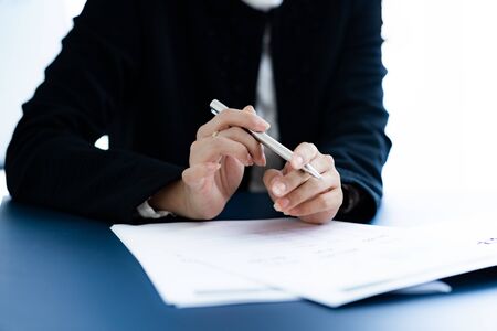 Asian business woman reviewing data in financial charts and graphs. Accounting conceptの写真素材