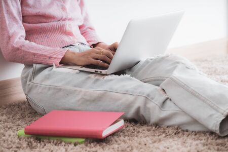 Asian young female lying on the floor in the living room student studying at home working with her laptop computer and class notes. Asia peopleの写真素材