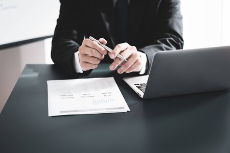 Businessman analyzing investment charts with laptop. Accounting conceptの写真素材