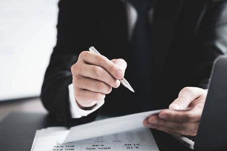 Businessman analyzing investment charts with laptop. Accounting conceptの写真素材
