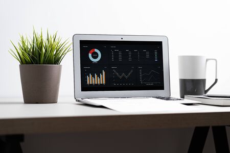 Laptop with  graph chart report screen on work table. Home office or work space. Strategy analysis financial accounting conceptの写真素材