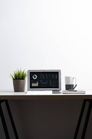 Laptop with  graph chart report screen on work table. Home office or work space. Strategy analysis financial accounting conceptの写真素材