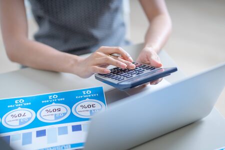 Asian business woman reviewing data in financial charts and graphs. Accountingの写真素材