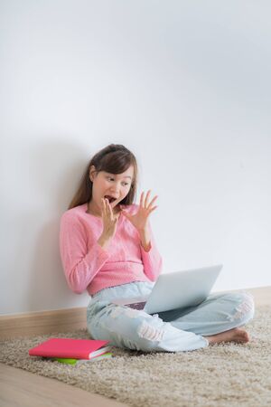 Asian young female lying on the floor in the living room student studying at home working with her laptop computer and class notes. Asia peopleの写真素材