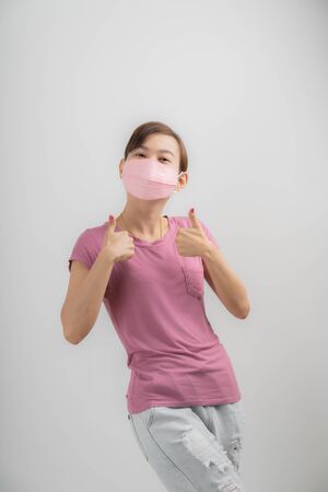 Close up portrait of young woman with medicine health care mask against white white background. CoronaVirus, Covid-19. Asian peopleの写真素材