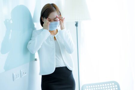 Asian woman using the medical face mask in officeの写真素材