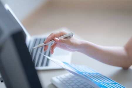 Asian business woman reviewing data in financial charts and graphs. Accountingの写真素材