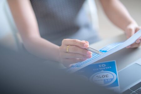 Asian business woman reviewing data in financial charts and graphs. Accountingの写真素材