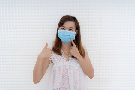 Close up portrait of young woman with medicine health care mask against white white background. CoronaVirus, Covid-19. Asian peopleの写真素材