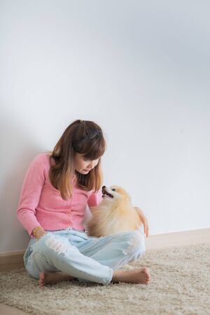 Young asian woman holding a beautiful and cute dogの写真素材
