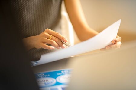 Asian business woman reviewing data in financial charts and graphs. Accountingの写真素材