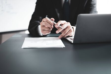 Businessman analyzing investment charts with laptop. Accounting conceptの写真素材