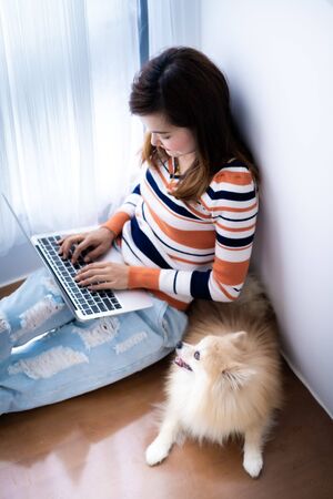 Asia student studying with laptop and dog at home. Education Concept. Asian peopleの写真素材