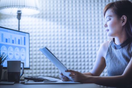Asian business woman reviewing data in financial charts and graphs. Accountingの写真素材