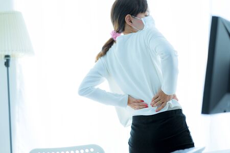 Asian woman with back pain in officeの写真素材