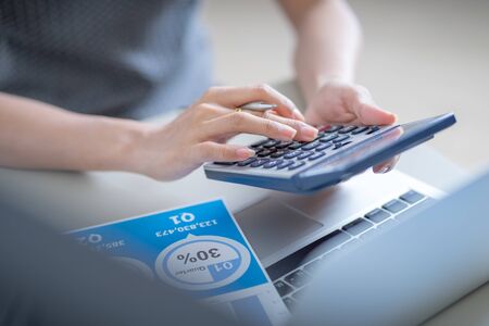 Asian business woman reviewing data in financial charts and graphs. Accountingの写真素材