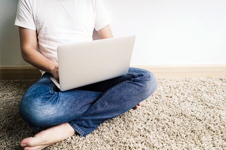 Man using laptop On the floor. Work from home conceptの写真素材