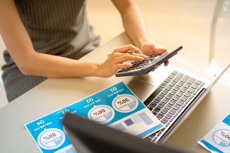 Asian business woman reviewing data in financial charts and graphs. Accountingの写真素材