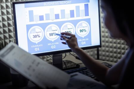 Asian business woman reviewing data in financial charts and graphs. Accountingの写真素材
