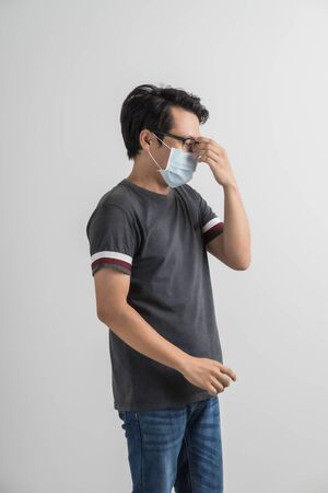 Portrait of young man with medicine health care mask against white gray background. Asian peopleの写真素材