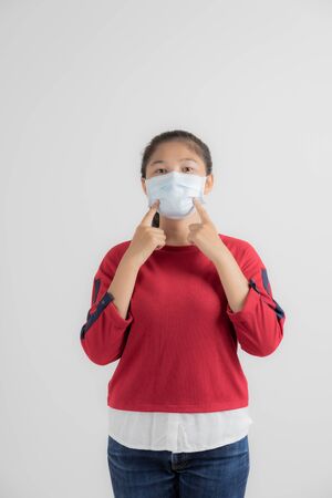 Close up portrait of young woman with medicine health care mask against white white background. CoronaVirus, Covid-19. Asian peopleの写真素材