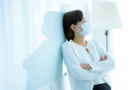 Asian woman using the medical face mask in officeの写真素材