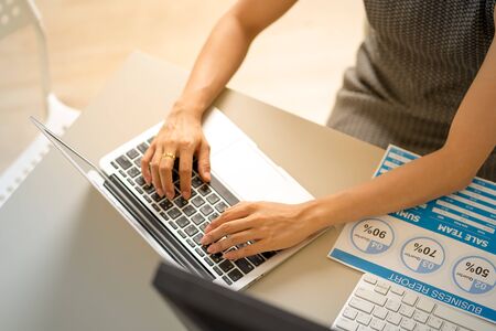 Asian business woman reviewing data in financial charts and graphs. Accountingの写真素材